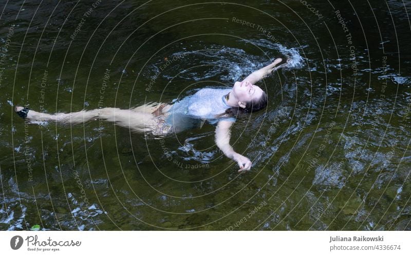 Frau liegt entspannt im Wasser Im Wasser treiben Schwimmen & Baden See Wellen Außenaufnahme Natur Farbfoto Teich Wasseroberfläche Gedeckte Farben ruhig nass