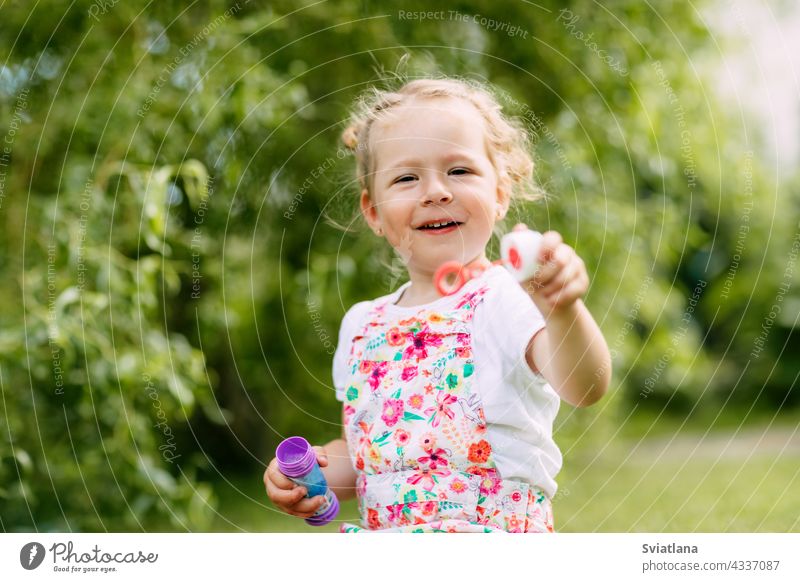 Charmantes Baby Mädchen mit Seifenblasen im Park oder Garten wenig Blasen Freude Kindheit grün Spaß Porträt Schlag schön Sommer spielen niedlich Natur lustig
