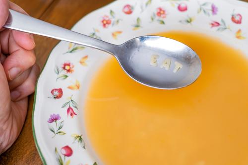 essen Nachricht auf einem Löffel auf einer Schüssel mit Buchstabensuppe auf einem Holztisch Suppe Speise Teller Essen Briefe Lebensmittel Text Spätzle Alphabet