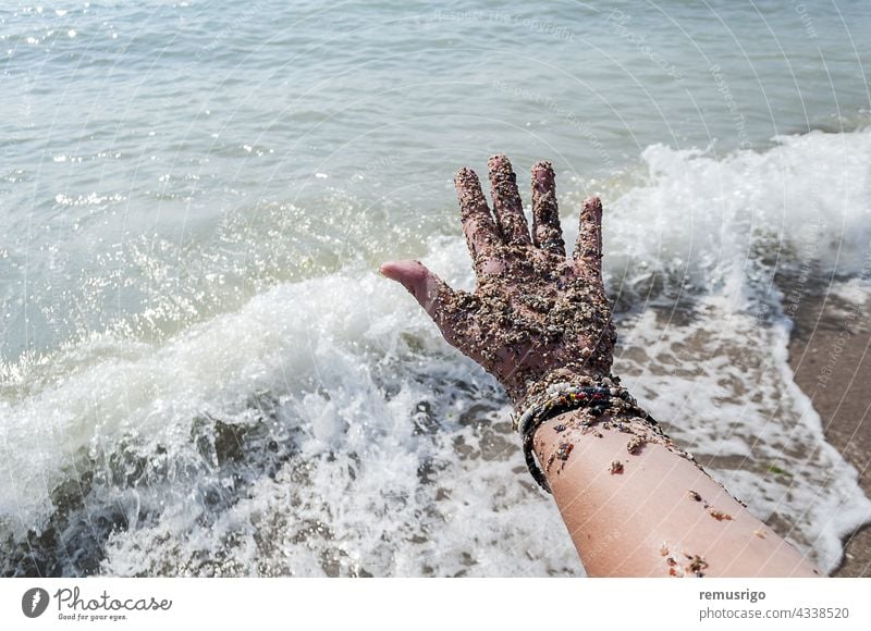 Mit Sand bedeckte Hand Erwachsener Strand Körper Armband Kaukasier Küstenlinie Frau Finger schäumen Feiertag menschlich Insel Natur Meer im Freien Scheitel