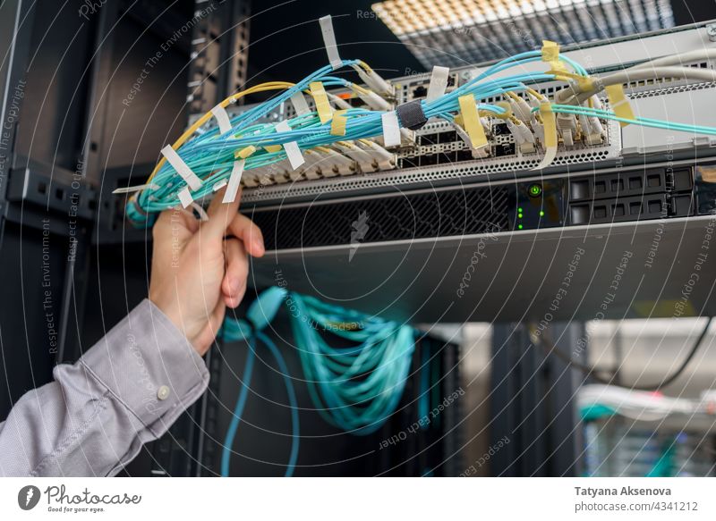 Mann Rechenzentrumstechniker bei der Server-Wartung Infrastruktur Techniker Datenzentrum Flugzeugwartung Ingenieur Ablage Kabel ersetzt Klinge montiert Sehne