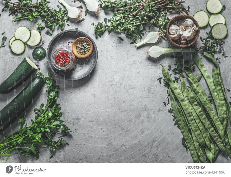 Verschiedene gesunde grüne Gemüse und Kräuter Zutaten auf konkrete Küche Tisch Hintergrund. Ansicht von oben. Hausmannskost. Veganes Essen verschiedene