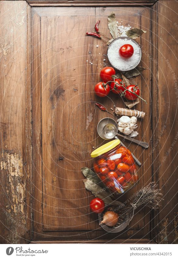 Tomaten einmachen.  Glas mit fermentierten Tomaten auf Holztisch Hintergrund mit Zutaten. Ansicht von oben hölzern Tisch Draufsicht niemand natürlich