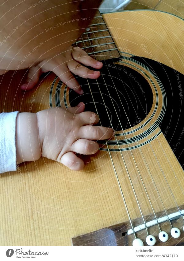 Kleinkind mit Gitarre kleinkind baby gitarre schallloch instrument lernen neugier spiel hand finger spiel spielen kinderspiel saite saiteninstrument musikschule