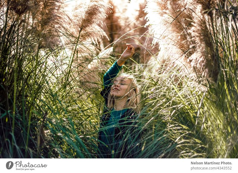Porträt einer schönen blonden Frau um die Pflanzen im Freien Gelassenheit Stil Selbstvertrauen Glück sich[Akk] entspannen einsiedlerisch Mädchen Beteiligung