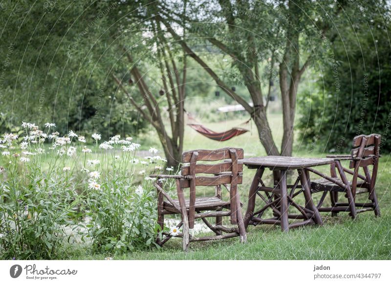 wohlfühlzone. sitzgruppe Holztisch Holzstuhl holzmöbel Natur Blumen Hängematte ausruhen chillen Teichufer Bäume Sommer Außenaufnahme Pause Sitzgelegenheit