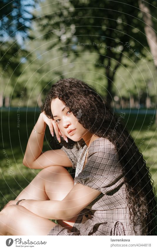 Junge schöne asiatische Frau sitzt auf dem Gras in einem Park Kleid Glück Menschen Erwachsener Person Lifestyle im Freien jung Sommer Wiese Weiblichkeit