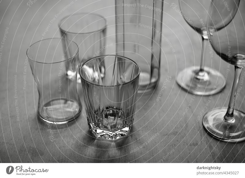Stillleben aus unterschiedlichen und gleichen Gläsern auf einem Holztisch Gastronomie Glas Tisch Restraurant Lockdown Pandemie Leere Verluste Hoffnung Rein