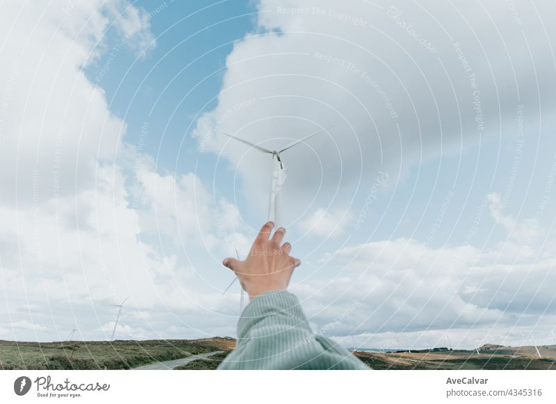 Menschliche Hand erreicht Windturbinen Windmühle Energie auf der Natur, während einer super sonnigen Tag, mit Kopie Raum und viel Luft Elektrizität Kraft