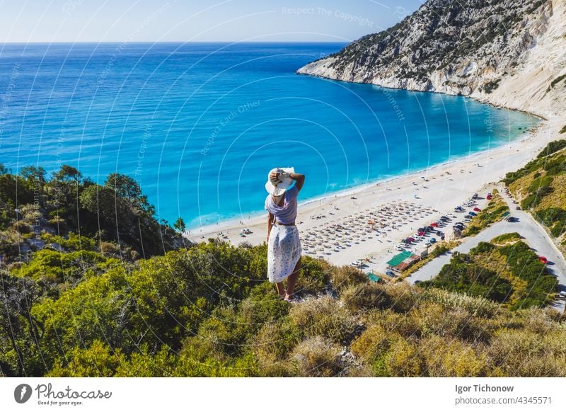 Glückliche Frau steht auf einem Felsen mit Hut und genießt den Strand von Myrtos. Insel Kephalonia, Griechenland myrtos Antenne Kefalonia schön Ansicht Bucht