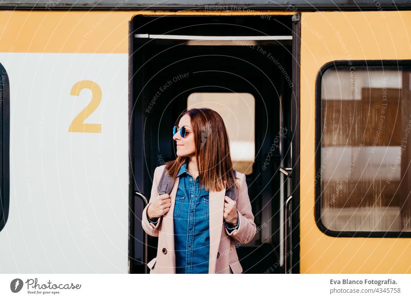 lächelnde junge Backpacker kaukasische Frau steht auf Wagen am Bahnhof. Reisen Konzept Handy reisen Kaukasier Glück Technik & Technologie Rucksack tagsüber
