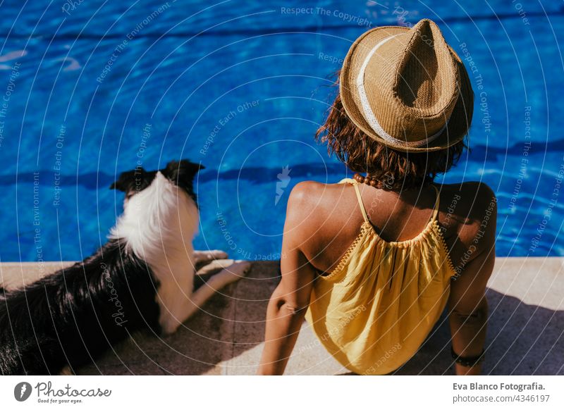 junge kaukasische Frau sitzt am Pool Seite mit niedlichen Border Collie Hund. Sommerzeit, Urlaub und Lebensstil Schwimmbad Zusammensein Liebe Besitzer