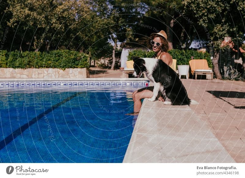 junge kaukasische Frau sitzt am Pool Seite mit niedlichen Border Collie Hund. Sommerzeit, Urlaub und Lebensstil Schwimmbad Zusammensein Liebe Besitzer