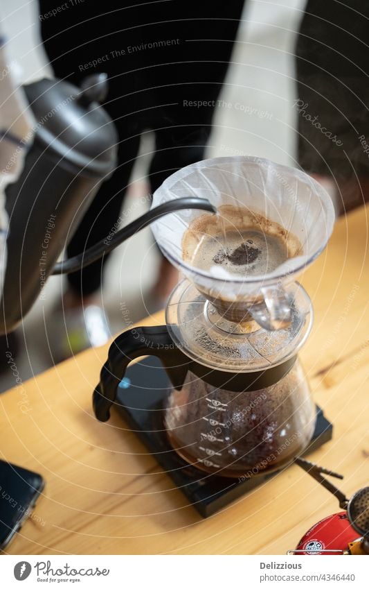 Zubereitungsprozess von V60-Kaffee, Filterkaffee, Aufgießen von heißem Wasser auf den Kaffee v60 eingießen Hintergrund brauen Papier Herstellung Brauen Barista