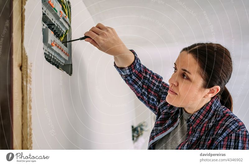 Elektriker, der an der Verteilertafel eines Hauses arbeitet Frau Elektrotechniker Schraubendreher Elektromonteur Elektroinstallation Besichtigung Prüfung