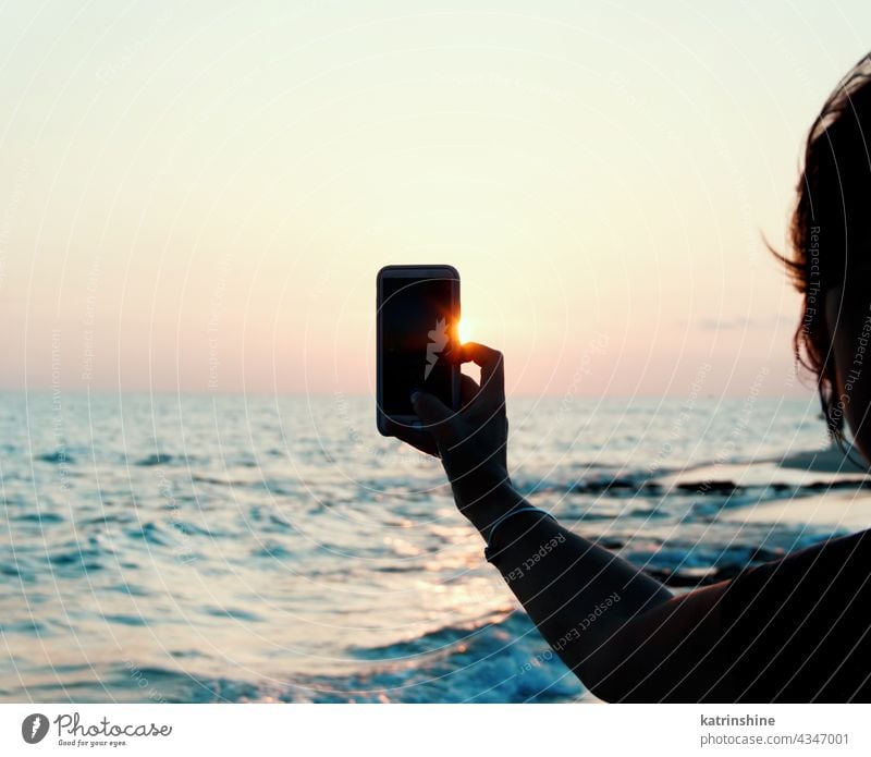 Frau nimmt ein Sonnenuntergangsfoto mit dem Mobiltelefon Hand Telefon abschließen fotografierend Strand MEER Landscapeб Mobile mobil blau Beteiligung