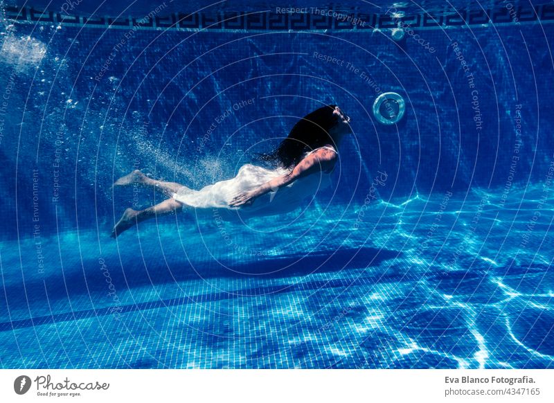 kaukasische Frau Tauchen im Schwimmbad trägt weißes Kleid.Unterwasser-Ansicht. Sommerzeit und Urlaub Konzept unter Wasser Spaß Liebe Blauwasser sonniger Tag