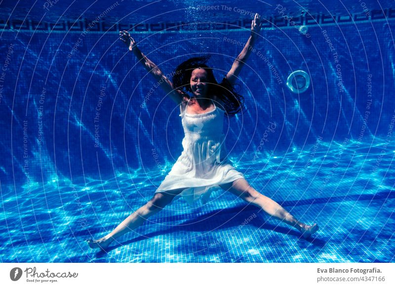 kaukasische Frau Tauchen im Schwimmbad trägt weißes Kleid.Unterwasser-Ansicht. Sommerzeit und Urlaub Konzept unter Wasser Spaß Liebe Blauwasser sonniger Tag