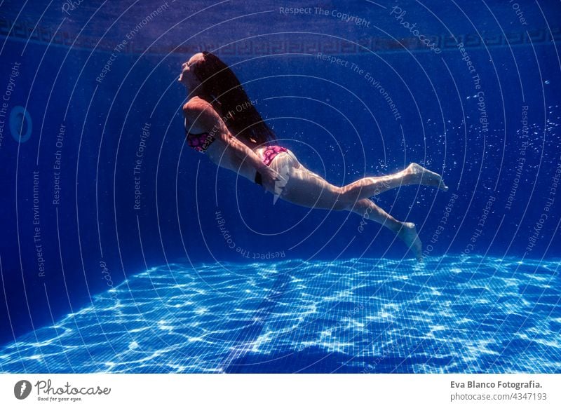 Kaukasische Frau Tauchen im Schwimmbad. Unterwasser-Ansicht. Sommerzeit und Urlaub Konzept unter Wasser Spaß Liebe Blauwasser sonniger Tag im Freien