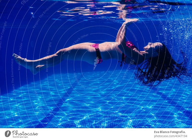Kaukasische Frau Tauchen im Schwimmbad. Unterwasser-Ansicht. Sommerzeit und Urlaub Konzept unter Wasser Spaß Liebe Blauwasser sonniger Tag im Freien