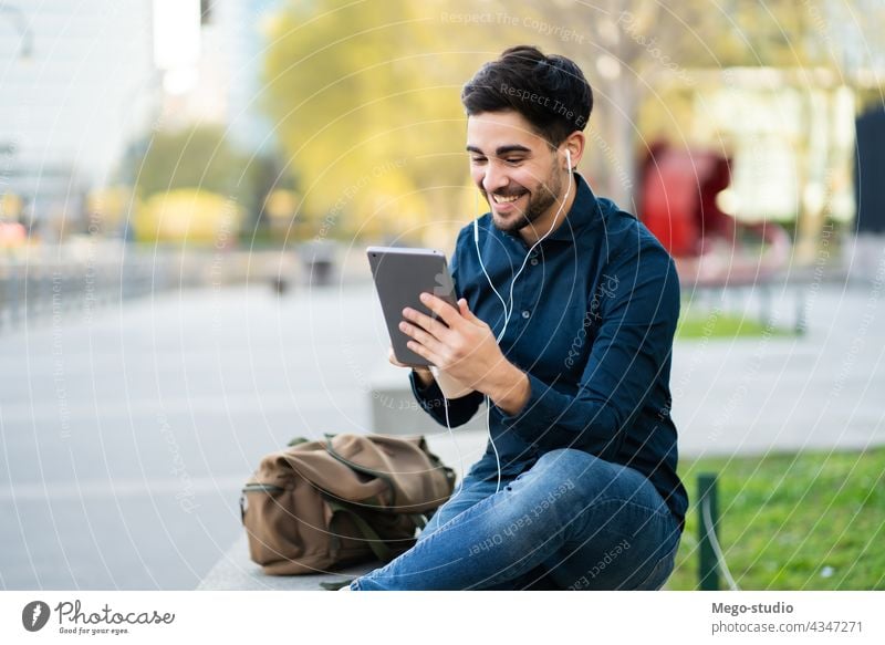 Junger Mann bei einem Videoanruf auf einem digitalen Tablet im Freien. jung Tablette Technik & Technologie Mobile arbeiten sozial Netzwerk Touchscreen außerhalb