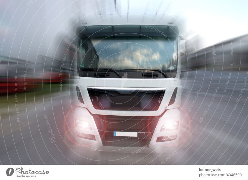 Ein Truck fährt mit blendenden Scheinwerfern auf den Betrachter zu LKW Lastwagen Lastkraftwagen Güterverkehr & Logistik Transport Spedition Fahrzeug Verkehr