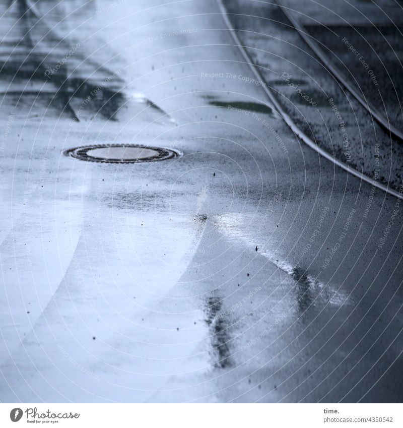 Gleis im Asphalt mit Abfluss, Pfütze und Spiegelung (2) schienenverkehr schwingung krümmung parallel wasser feucht nass grau Gullydeckel spiegelung Schienenweg