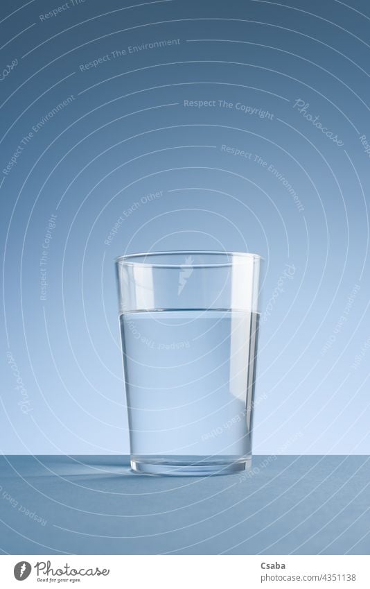 Minimalistisches Foto eines Glases sauberen Trinkwassers auf blauem Hintergrund Wasser Sauberkeit übersichtlich minimalistisch Getränk trinken liquide