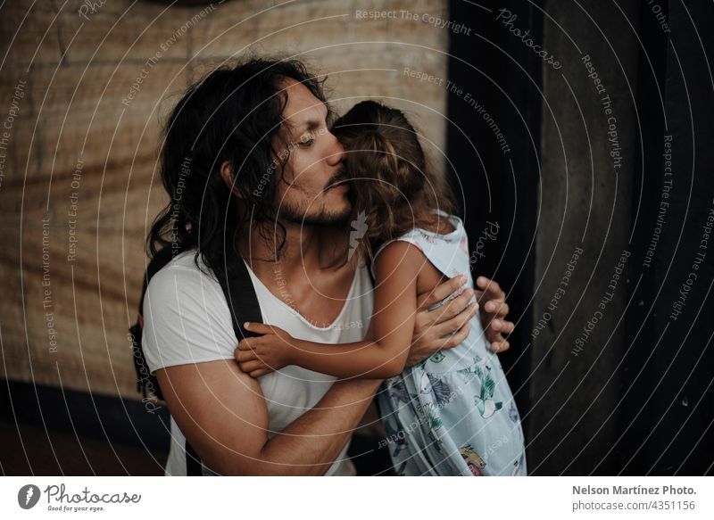 Vater mit langen schwarzen Haaren, der seine Tochter umarmt hispanisch Latein Porträt Familie Papa Kindheit Mädchen Frau männlich lange Haare Zusammensein Liebe