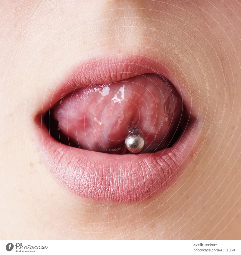 weiblicher Mund mit Zungenpiercing leckt sich Lippen Piercing zungenpiercing frech Nahaufnahme Frau Detailaufnahme anzüglich lecken Erotik