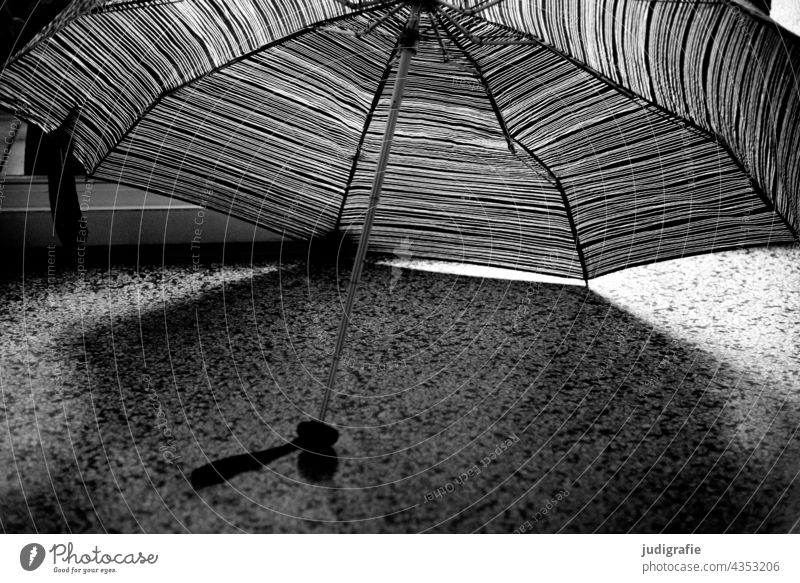 Zum Trocknen aufgespannter Regenschirm Schirm Linien Terrazzoboden Punkte Boden Licht Schatten Wetter nass schlechtes Wetter Klima Muster