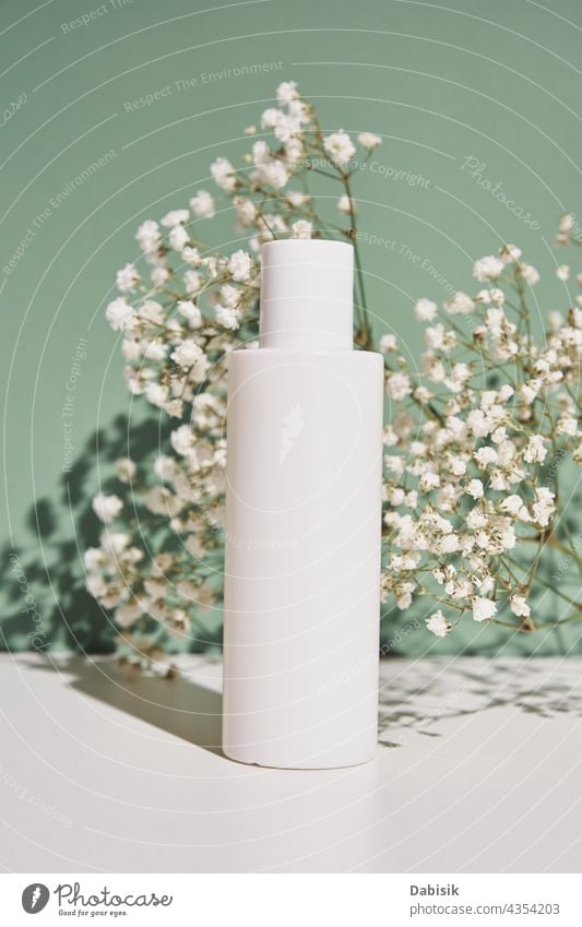 Natürliche kosmetische Creme Flasche auf grünem Hintergrund mit Pflanze Produkt Kosmetik Schönheit Paket Attrappe kennzeichnen Sauberkeit hygienisch Lotion