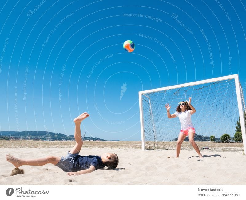 zwei Kinder spielen Fußball am Strand Glück Wasser heiter Freundlichkeit Ufer Meer Sommer lässig MEER Zusammensein Freude Nähe Lächeln Urlaub Sport kurzweilig