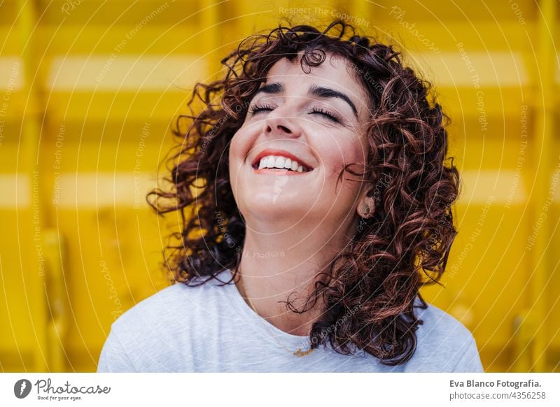 Nahaufnahme von glücklichen kaukasischen Frau mit lockigem Haar über gelben Hintergrund. Sommerzeit. Lebensstil im Freien Glück Kaukasier gelber Hintergrund