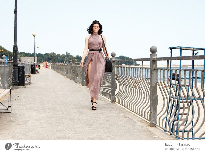 junge schöne Frau, die im Sommer auf dem Bürgersteig geht laufen Kleid Bein Mode Mädchen im Freien Glück Model Großstadt Erwachsener Schönheit Straße Lifestyle