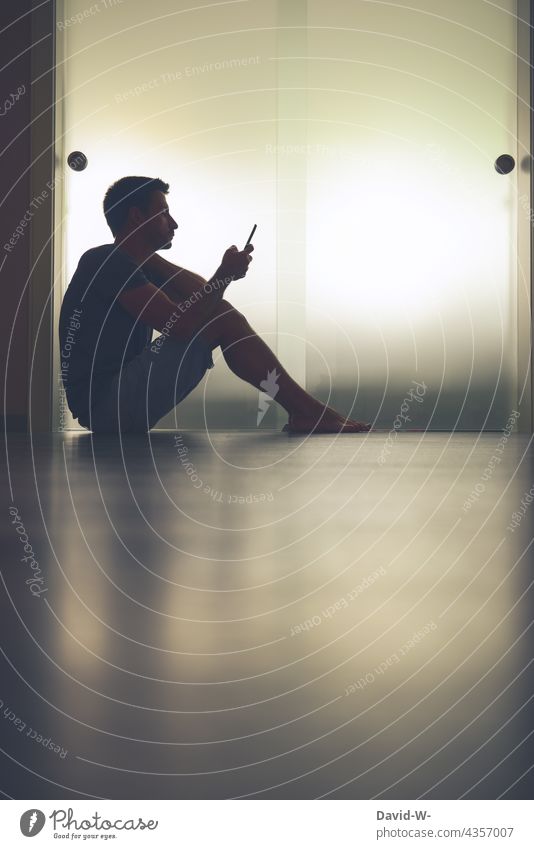 Mit dem Handy in der Hand Nachrichten lesen Mann gelangweilt Telefon sitzen Mitteilung Internet Lifestyle