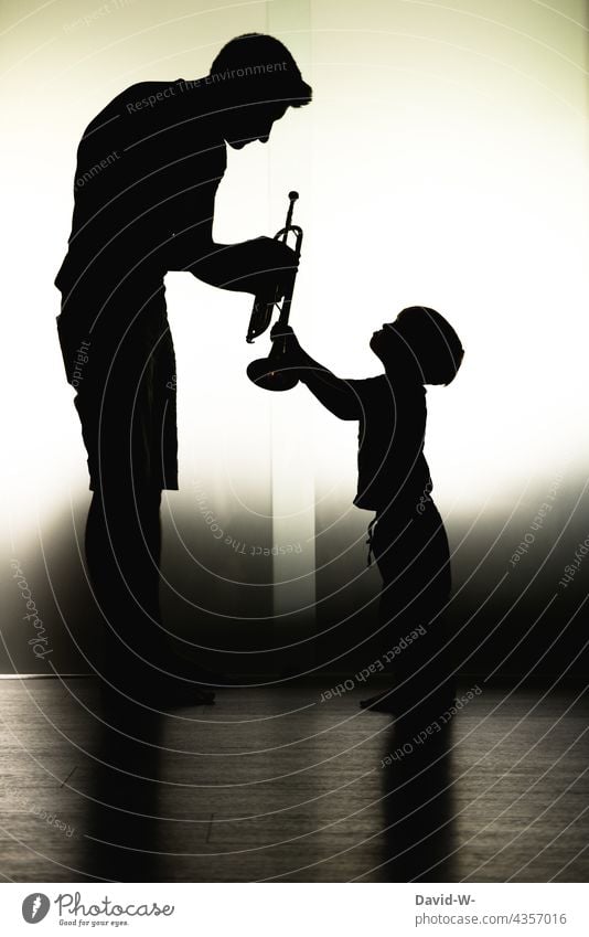 Vater und Kind - Kindererziehung - Fürsorge Papa Sohn Musik Instrument lernen zeigen Zusammensein Eltern gemeinsam Liebe Schatten Schattenspiel