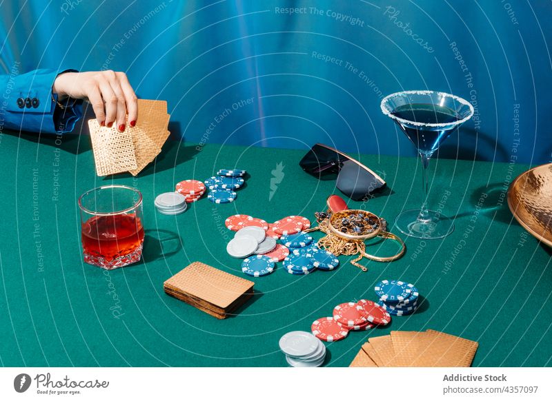 Crop anonyme Frau beim Pokern Schüreisen spielen Spiel unterhalten Postkarte Chip Glücksspiel Wette Spieler Tisch sitzen grün Nachtleben Vergnügen Süchtige