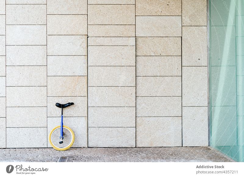Einrad in der Nähe eines modernen Gebäudes geparkt urban Rad Verkehr Zeitgenosse Fahrzeug Architektur Geometrie Außenseite Konstruktion Struktur Stein Form Glas