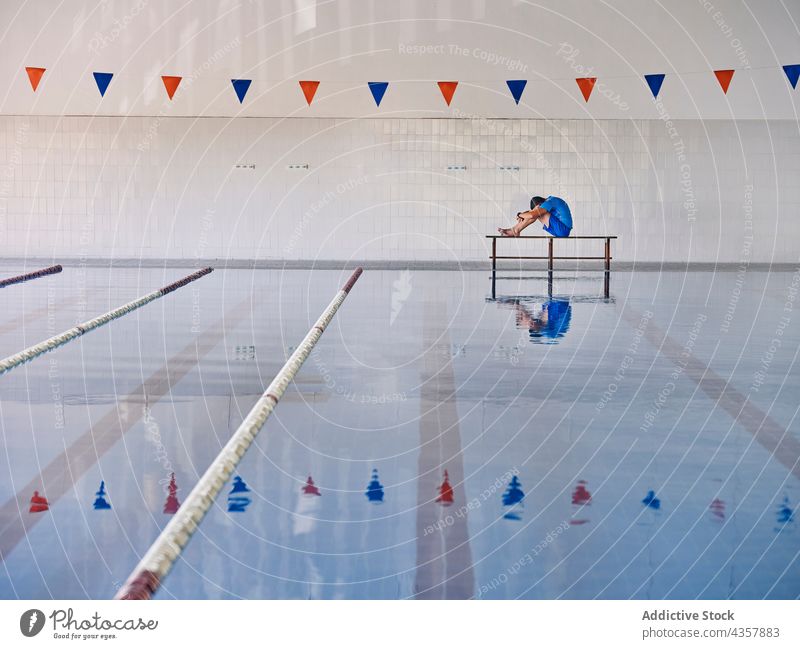 Wassergymnastik-Lehrer beim Training im Schwimmbad Aerobic Trainerin Übung Ausbilderin Pool Beckenrand Dehnung Aufwärmen üben passen sitzen Knie umarmend