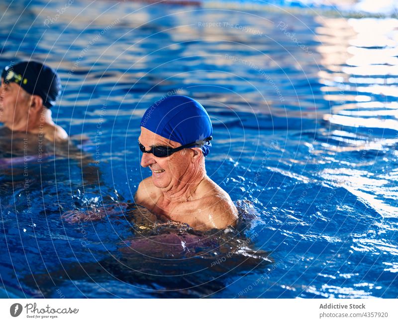 Gesellschaft von Menschen bei Übungen mit Wassernudeln im Schwimmbad Aerobic aqua Nudel Training Menschengruppe Pool Aktivität schwimmen Sport schäumen