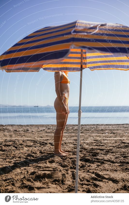 Anonyme Frau am Strand stehend Bikini passen Sommer Urlaub Sonnenschirm MEER reisen Feiertag blass anonym jung Rotschopf schlank orange Wasser Stuhl Sand