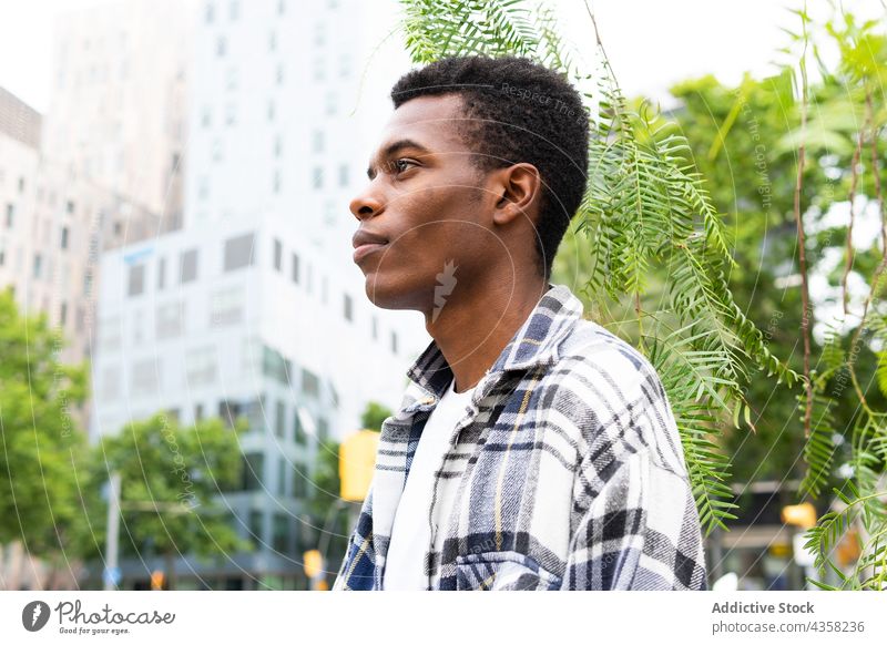 Ernster schwarzer Mann, der auf der Straße steht Großstadt urban männlich modern Stil trendy ethnisch Afroamerikaner sich[Akk] entspannen Kälte ruhen praktisch