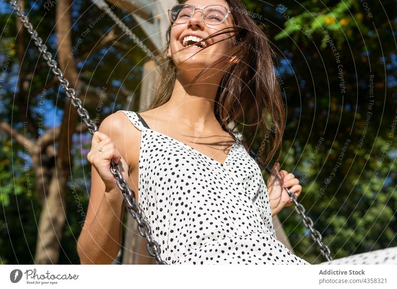 Lächelnde junge Frau beim Schwingen pendeln Spaß Park swinging Freiheit Sommer spielen Glück Person Fröhlichkeit Mädchen Freizeit Menschen Erwachsener schön
