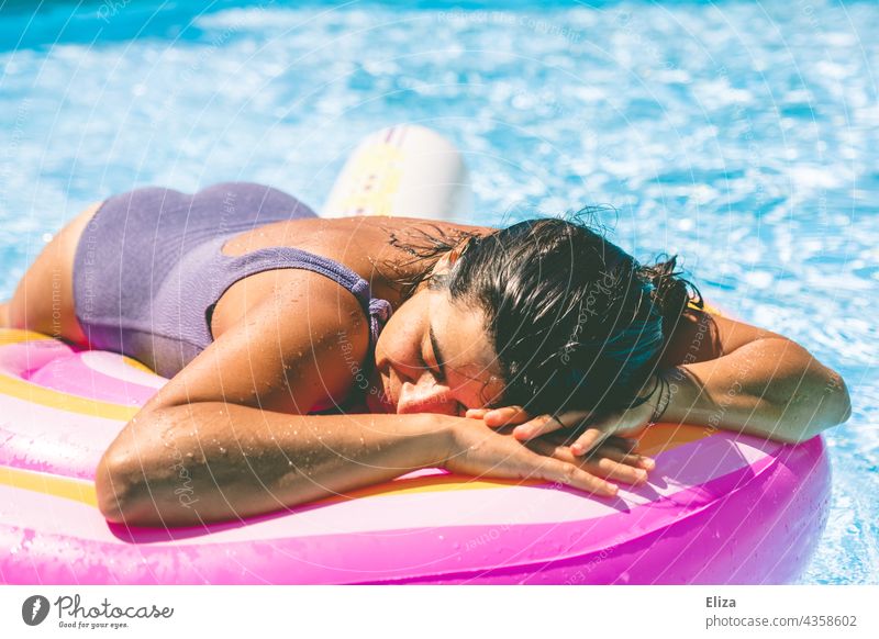 Frau mit lila Badeanzug liegt im Pool auf einer Luftmatratze und genießt die Sonne Sommer liegen sonnen Erholung Urlaub Wasser Ferien & Urlaub & Reisen