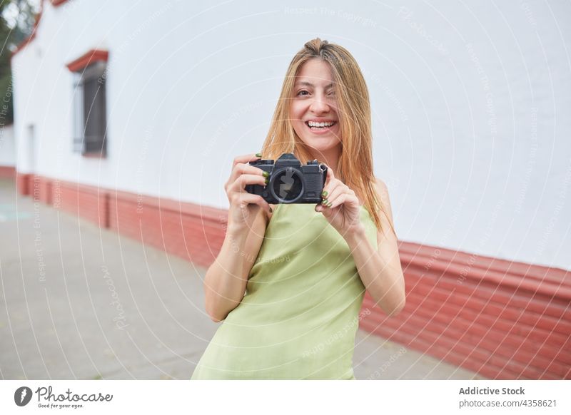 Fröhliche Frau, die ein Foto auf einer Fotokamera in der Stadt macht Fotograf fotografieren Fotoapparat Sommer urban heiter Fotografie Gedächtnis Großstadt