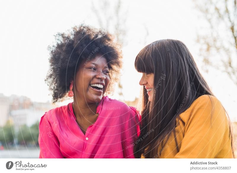 Unterschiedliche lesbische Frauen, die sich umarmen und gegenseitig anschauen Paar Homosexualität Lächeln Umarmen Liebe lgbt Partnerschaft Park multiethnisch