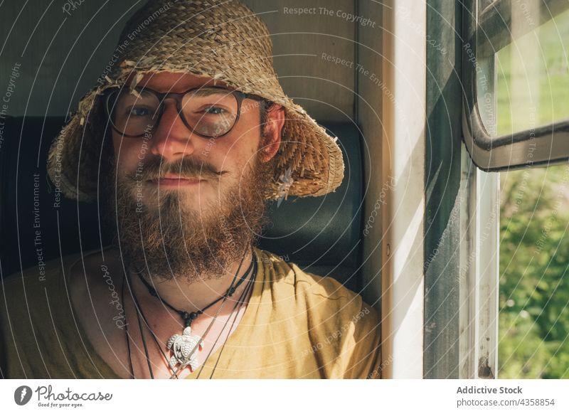 Inhalt Reisender Mann fährt im Zug und schaut in die Kamera reisen Fenster Hipster Strohhut Lächeln Entdecker Eisenbahn männlich Wagen Ausflug Sommer Urlaub