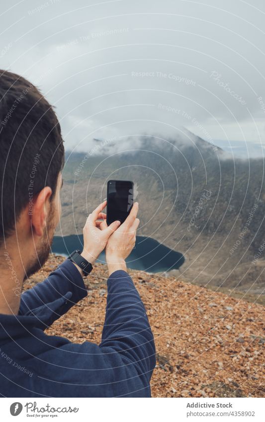 Reisender Mann, der an einem nebligen Tag die Berge fotografiert fotografieren Berge u. Gebirge Smartphone Wanderer Trekking Hochland Nebel männlich Wales