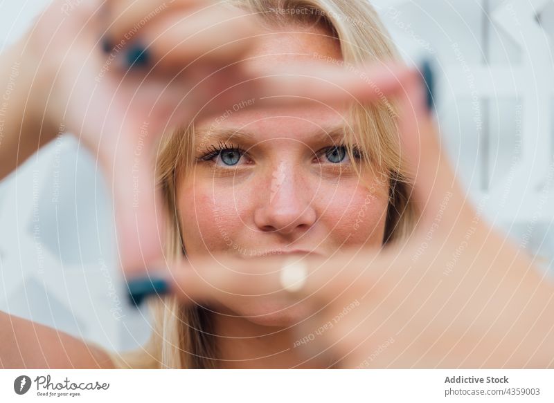Charmante Frau zeigt rahmende Geste in der Stadt Rahmen gestikulieren Zeichen charmant blond Symbol zeigen Foto Hand Inhalt manifestieren kreativ